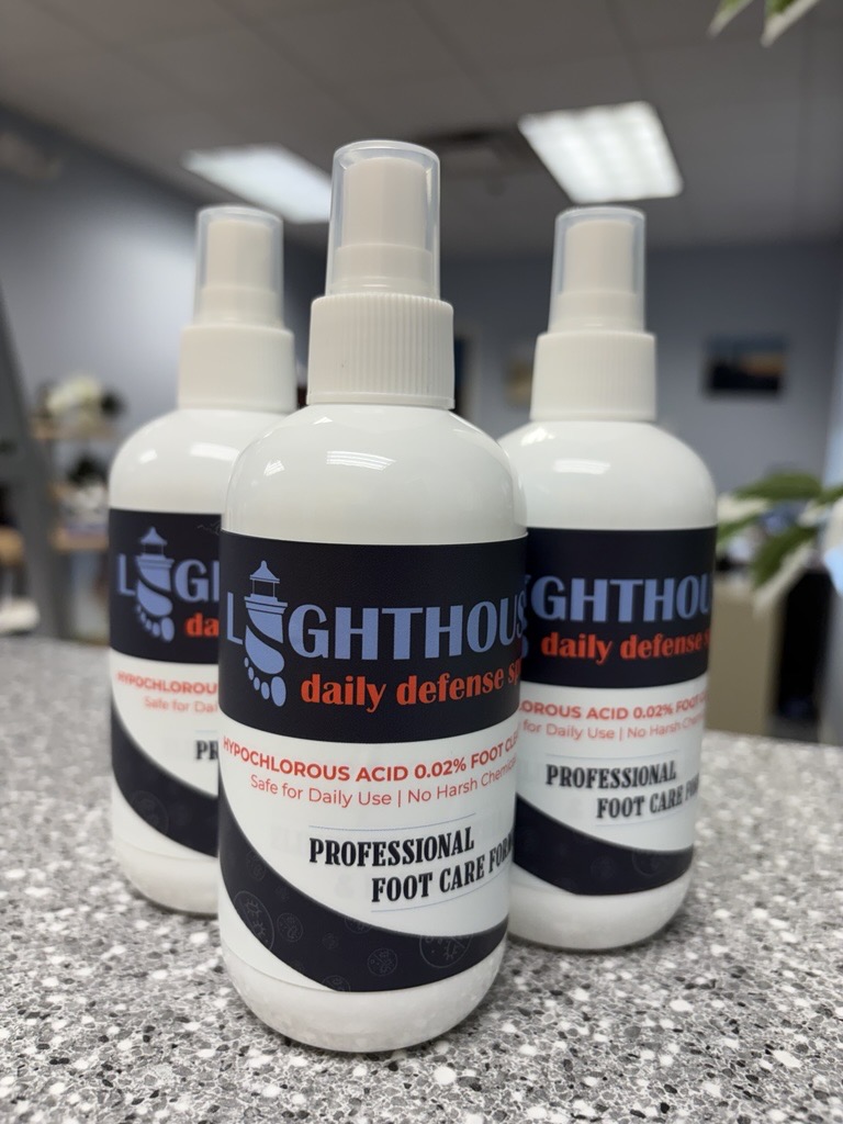 Three bottles of Lighthouse Daily Defense Spray on the counter at Lighthouse Foot and Ankle Center in Scarborough, Maine